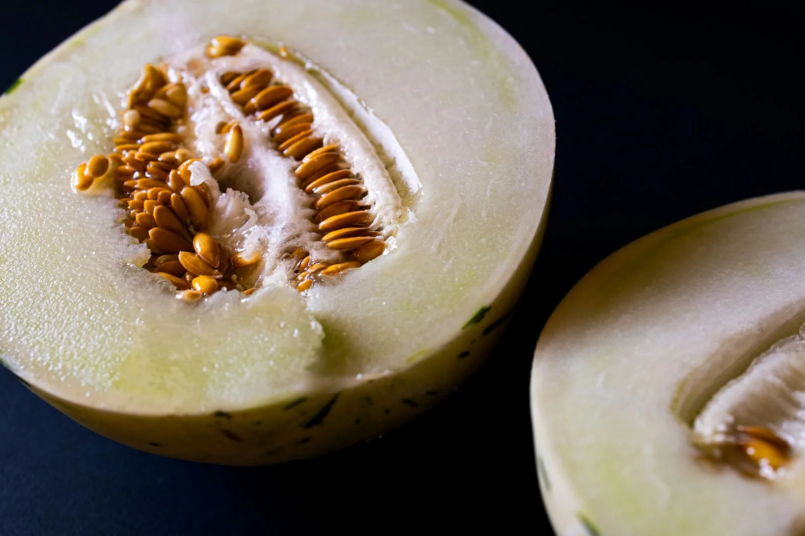 a halved honeydew melon with seeds visible
